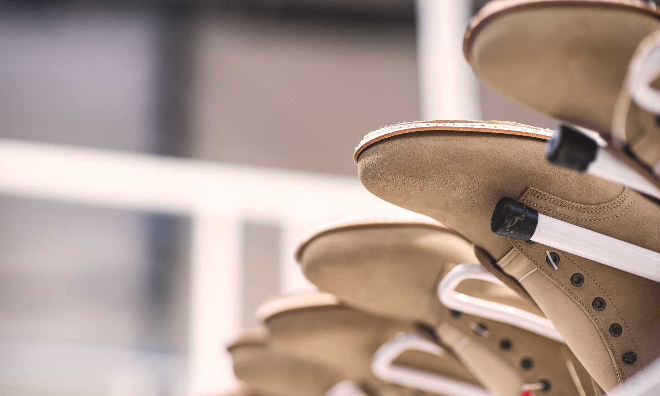 light tan boots upside down on racks in production