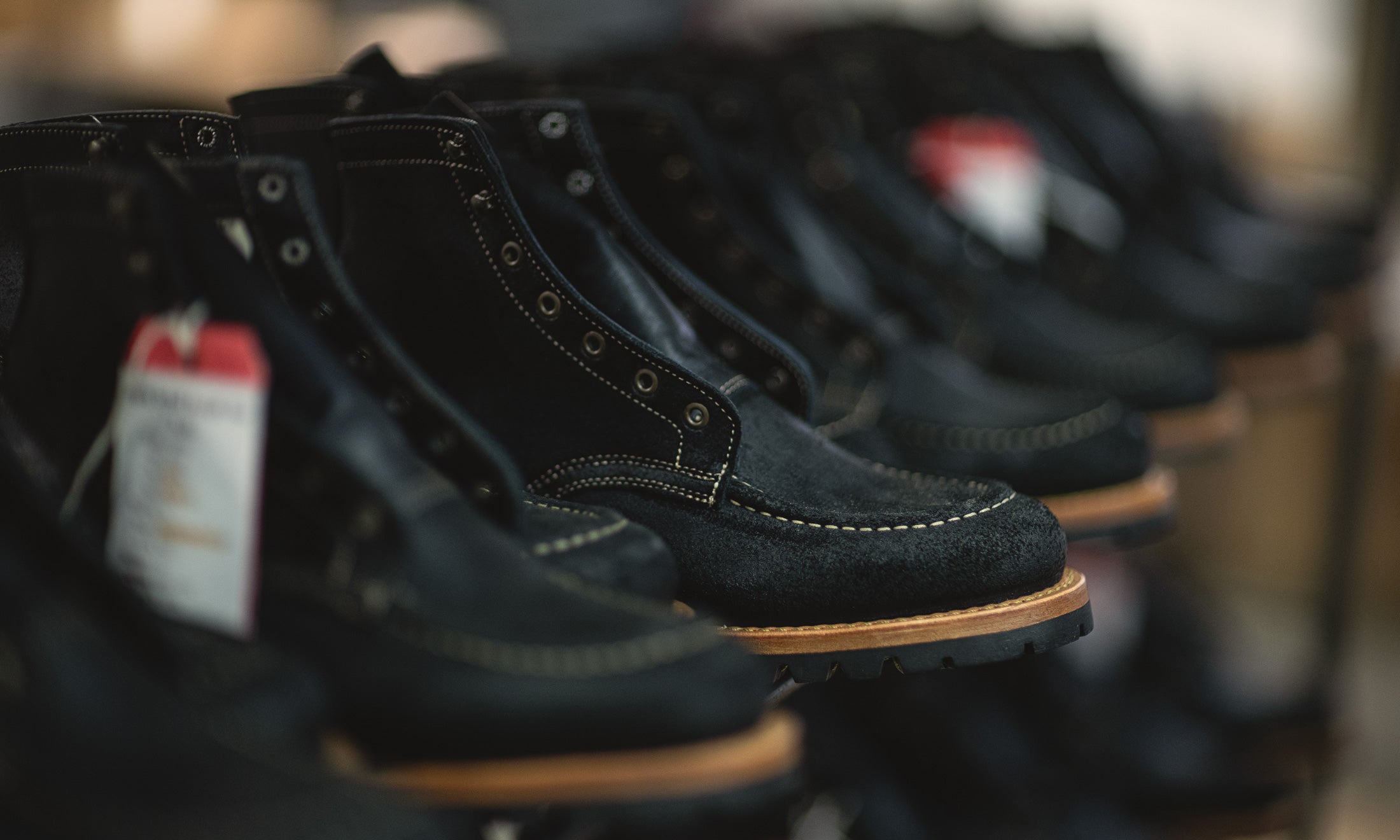 cascade of black rough out boots on finishing rack