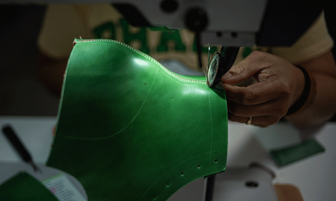 animated image of sewer sewing green horse leather boot