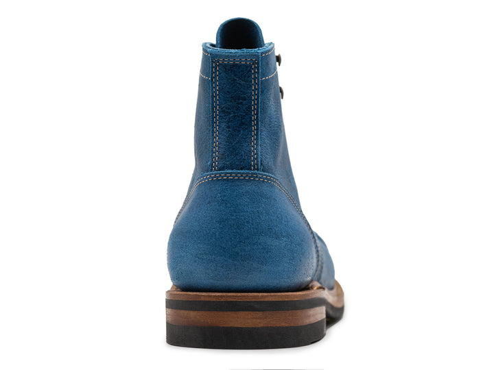 back view of blue textured leather boot on white background