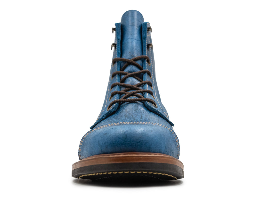front view of blue textured leather boot on white background