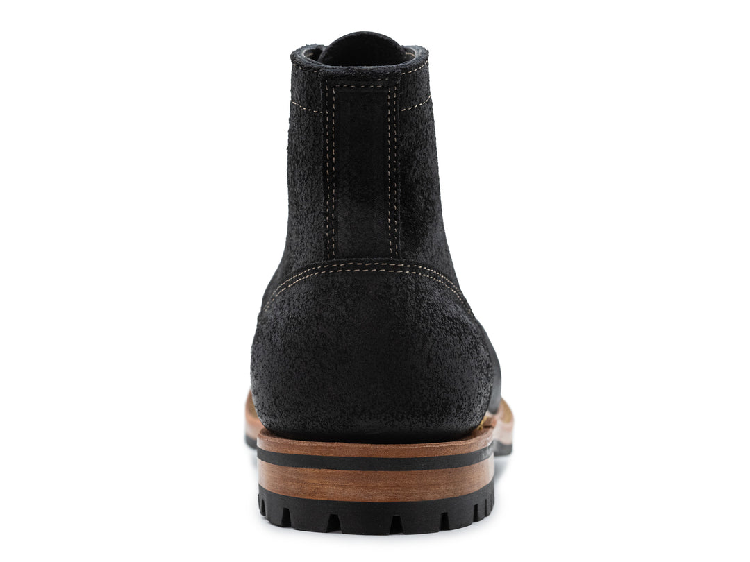 black leather boot on a white background view from behind