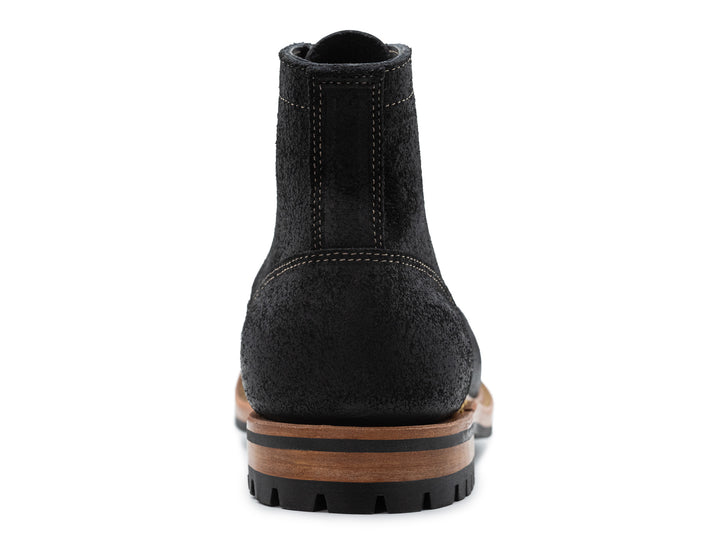 black leather boot on a white background view from behind