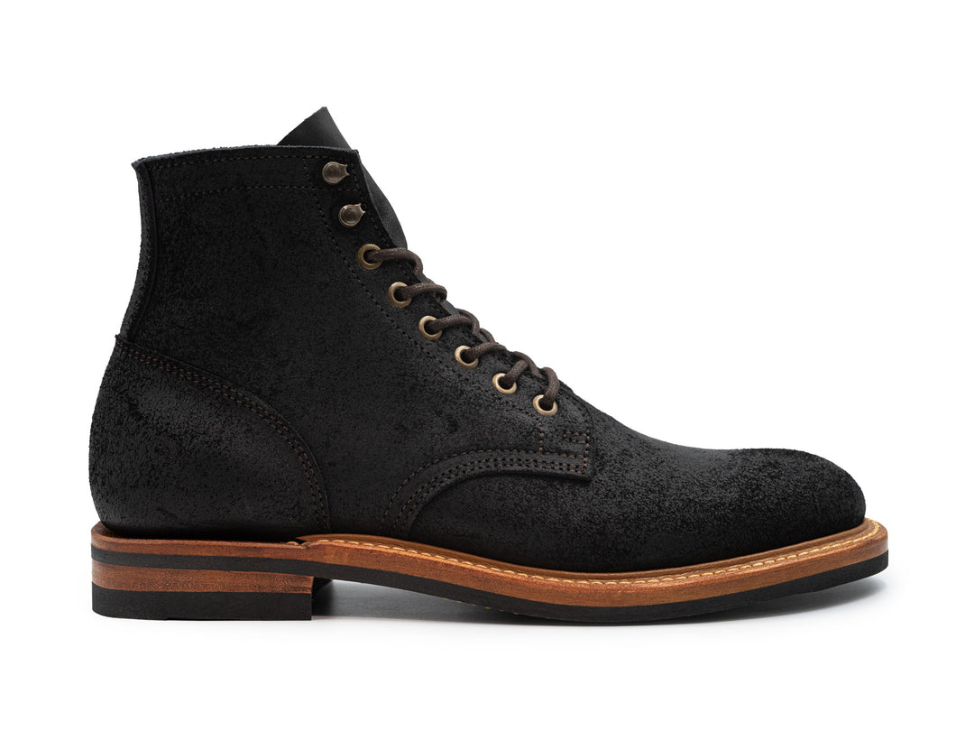 side view of black oiled rough out leather boot on white background