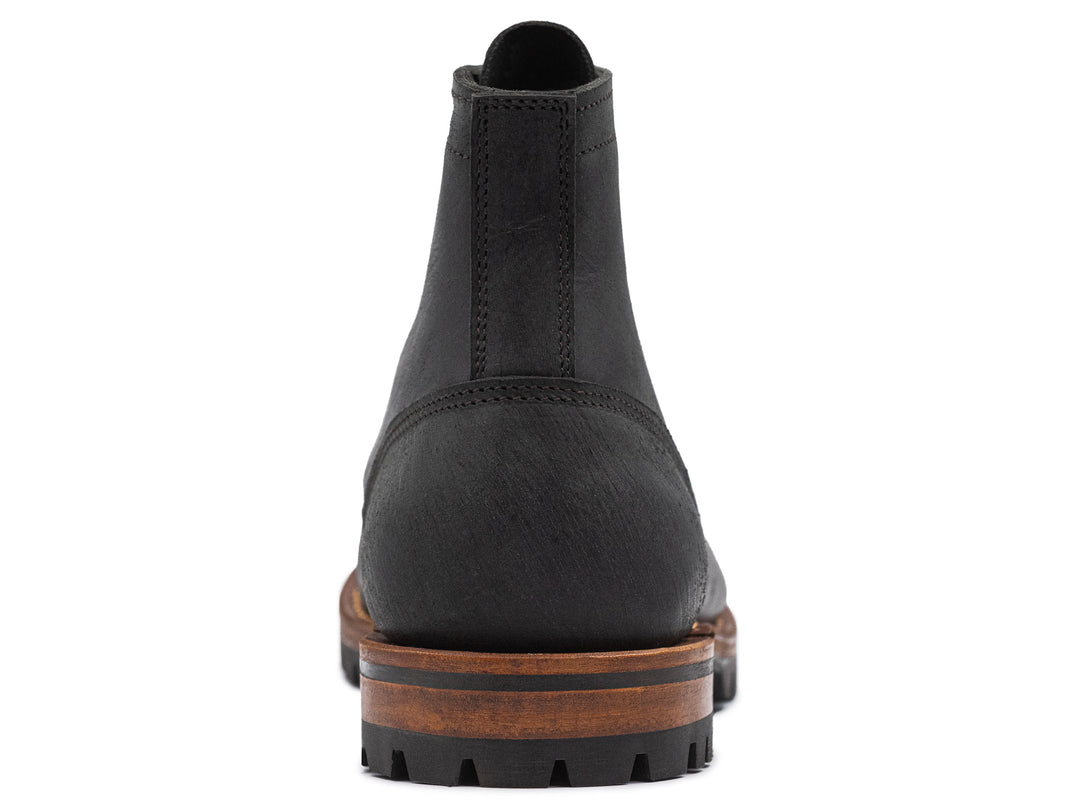 black leather boot on a white background view from behind