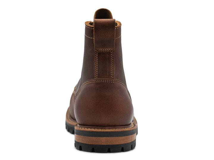 brown leather moc toe boot on a white background view from behind