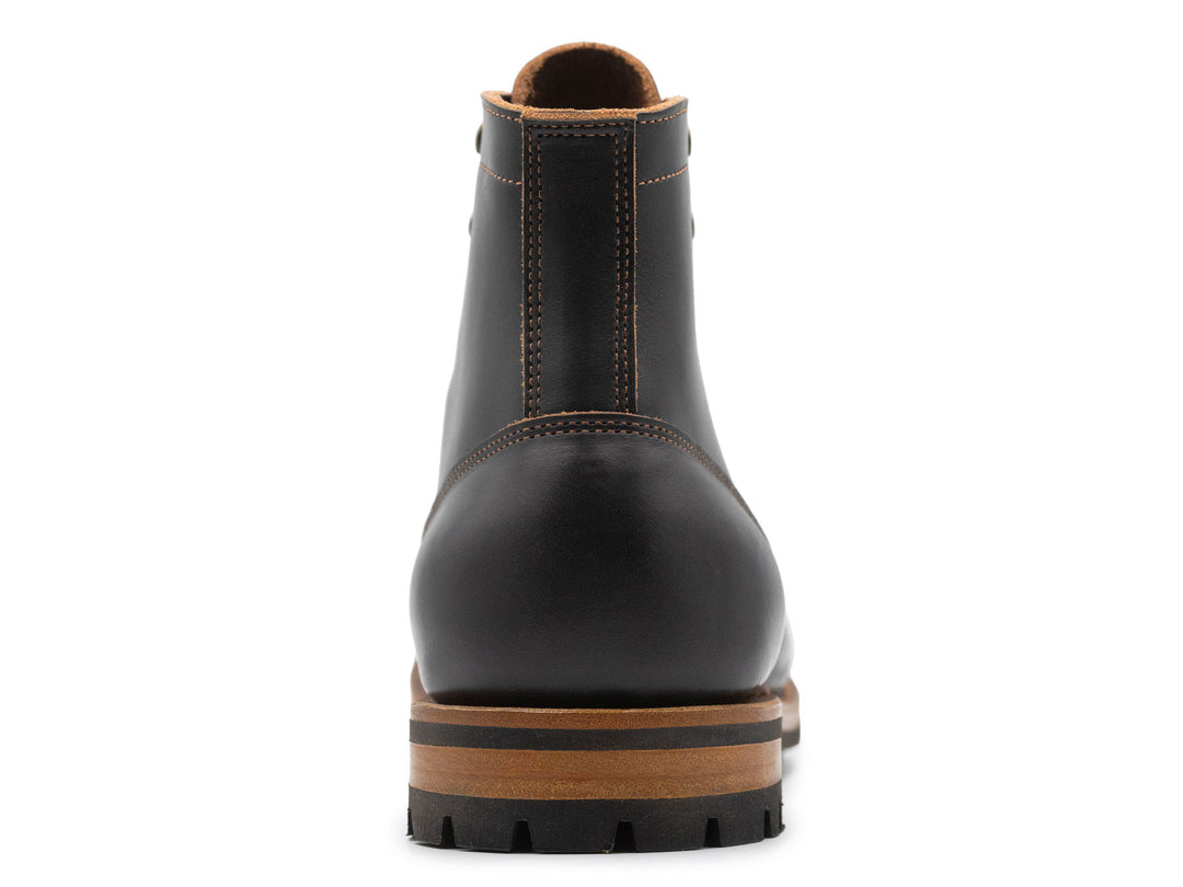 black leather boot on a white background view from behind