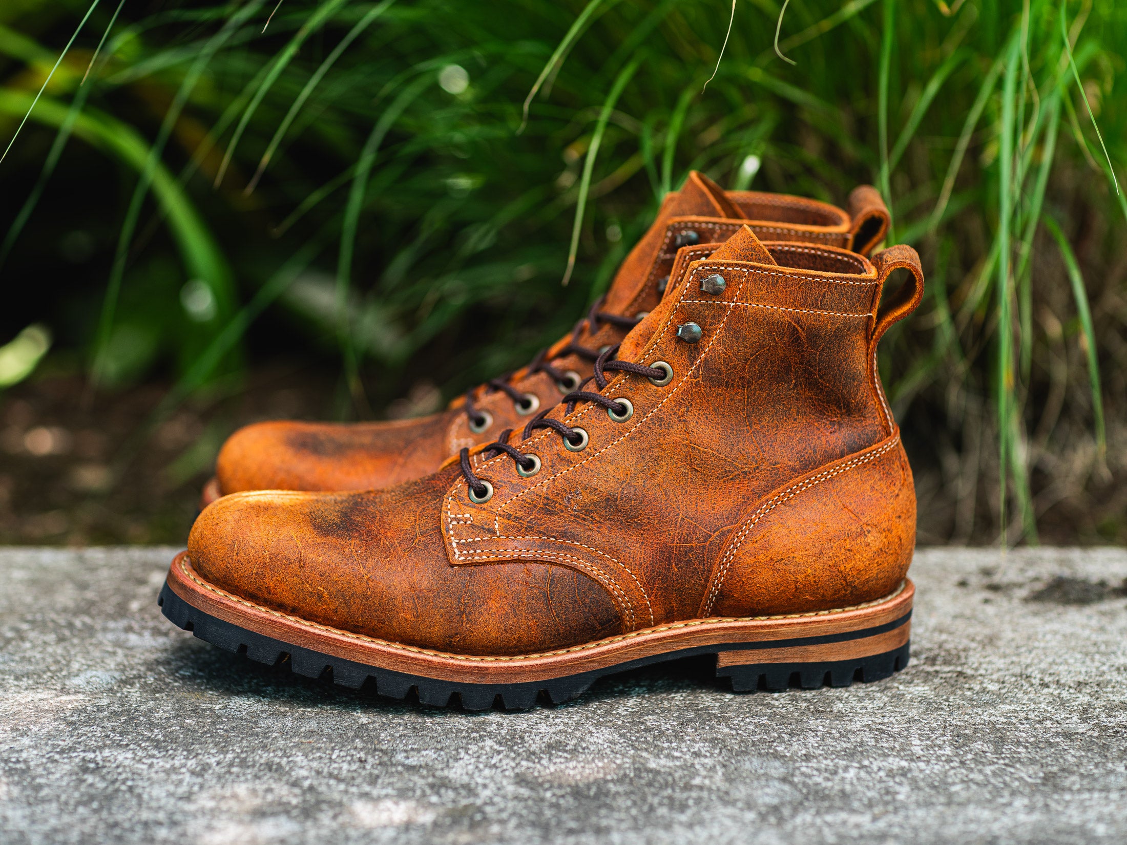 pair of orange textured boots with out of focus greenery behind