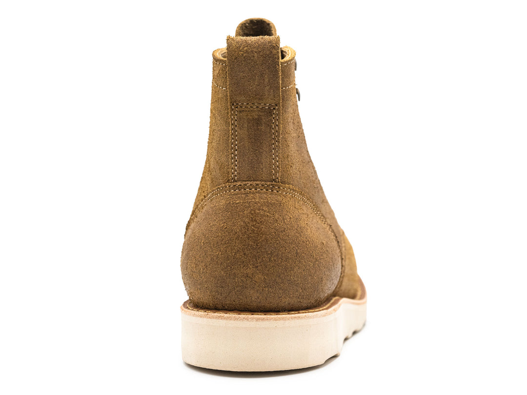 tan rough out leather moc toe boot on a white background view from behind