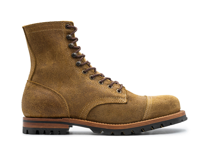 side view of coyote oiled rough out leather boot on white background