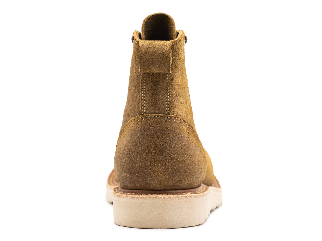 tan leather moc toe boot with yellow laces on a white background view from behind