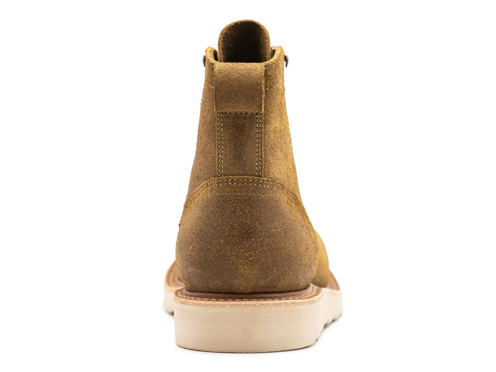 tan leather moc toe boot with yellow laces on a white background view from behind