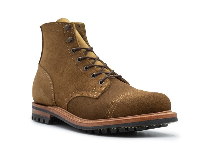 dark tan colored leather boot three-quarter view on white background