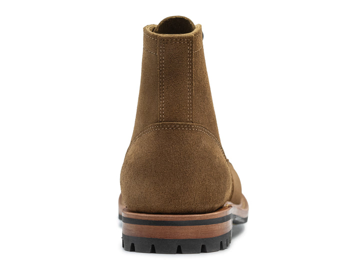 dark tan colored leather boot back view on white background