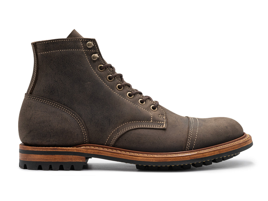 side view of gray leather boot on white background