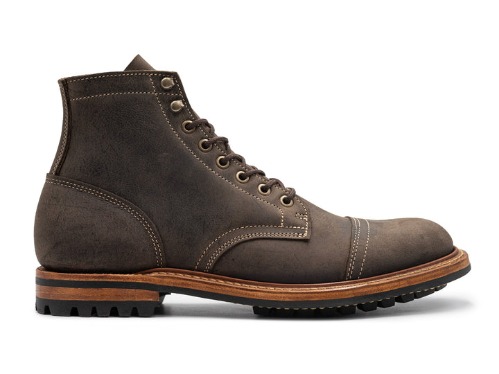 side view of gray leather boot on white background
