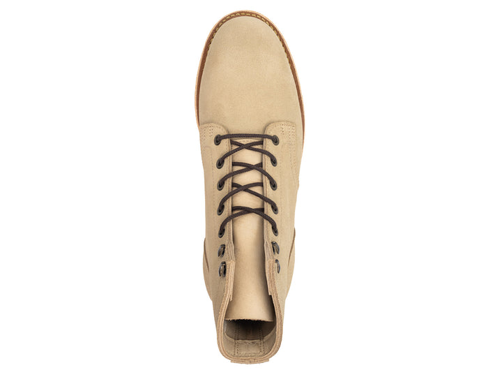 Tan boot with a white sole on a white background topdown view