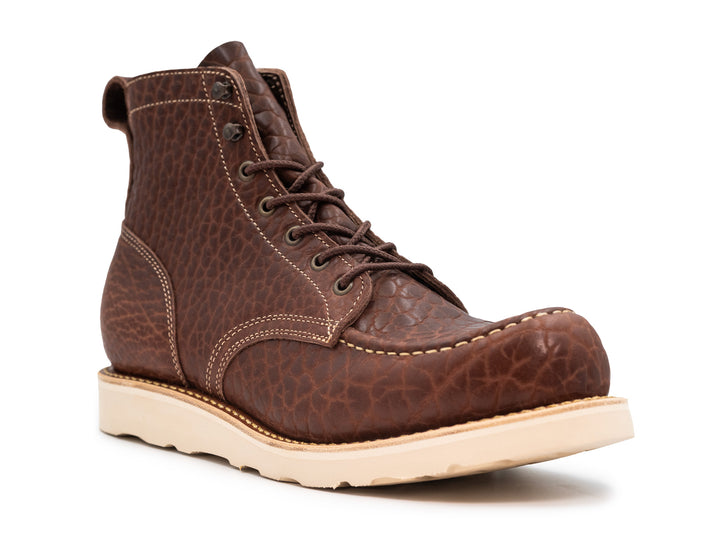 three-quarter view of brown textured leather boot with wedge sole on white background