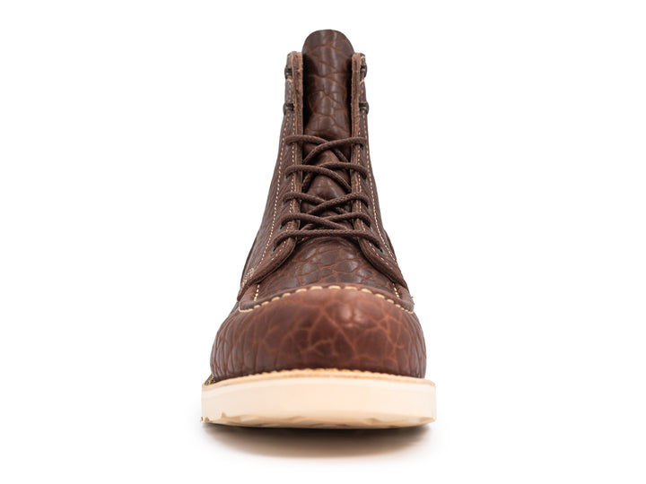 front view of brown textured leather boot with wedge sole on white background