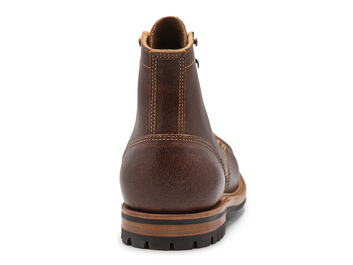 brown leather cap toe boot on a white background view from behind