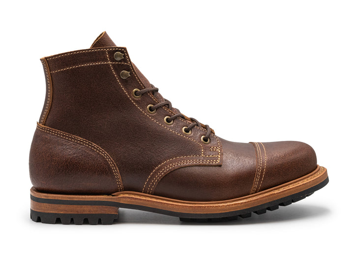 brown leather cap toe boot on a white background side view