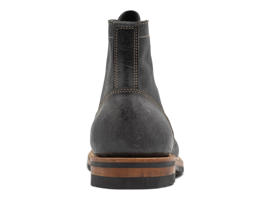 back view of gray textured leather boot on white background