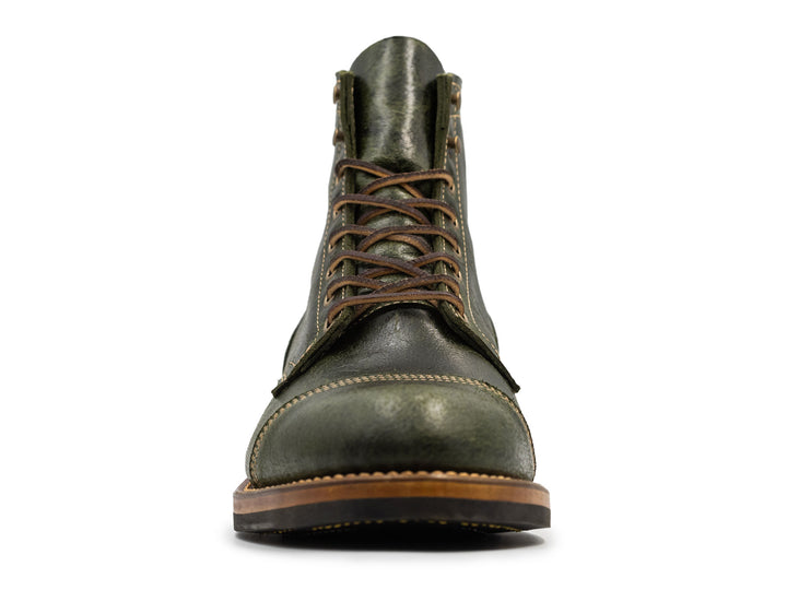 fonrt view of a textured green leather boot on white background