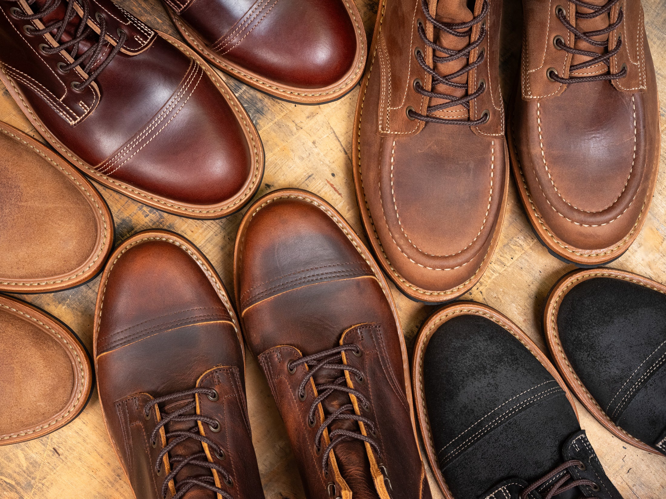 variety of leather boots topdown on wood