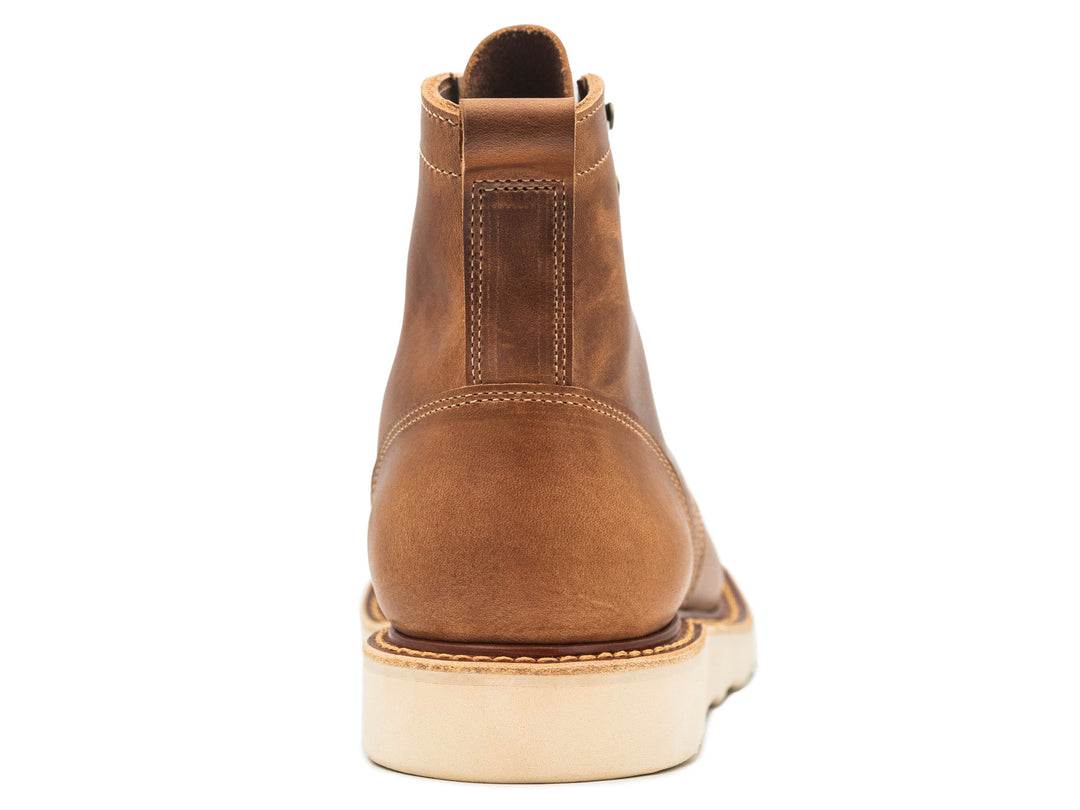 tan leather boot on a white background view from behind
