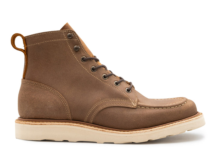 side view of brown leather boot on white background