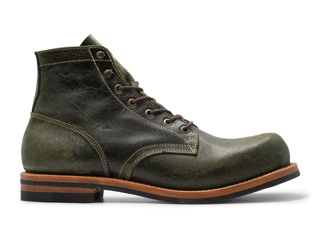 side view of green textured leather boot on white background