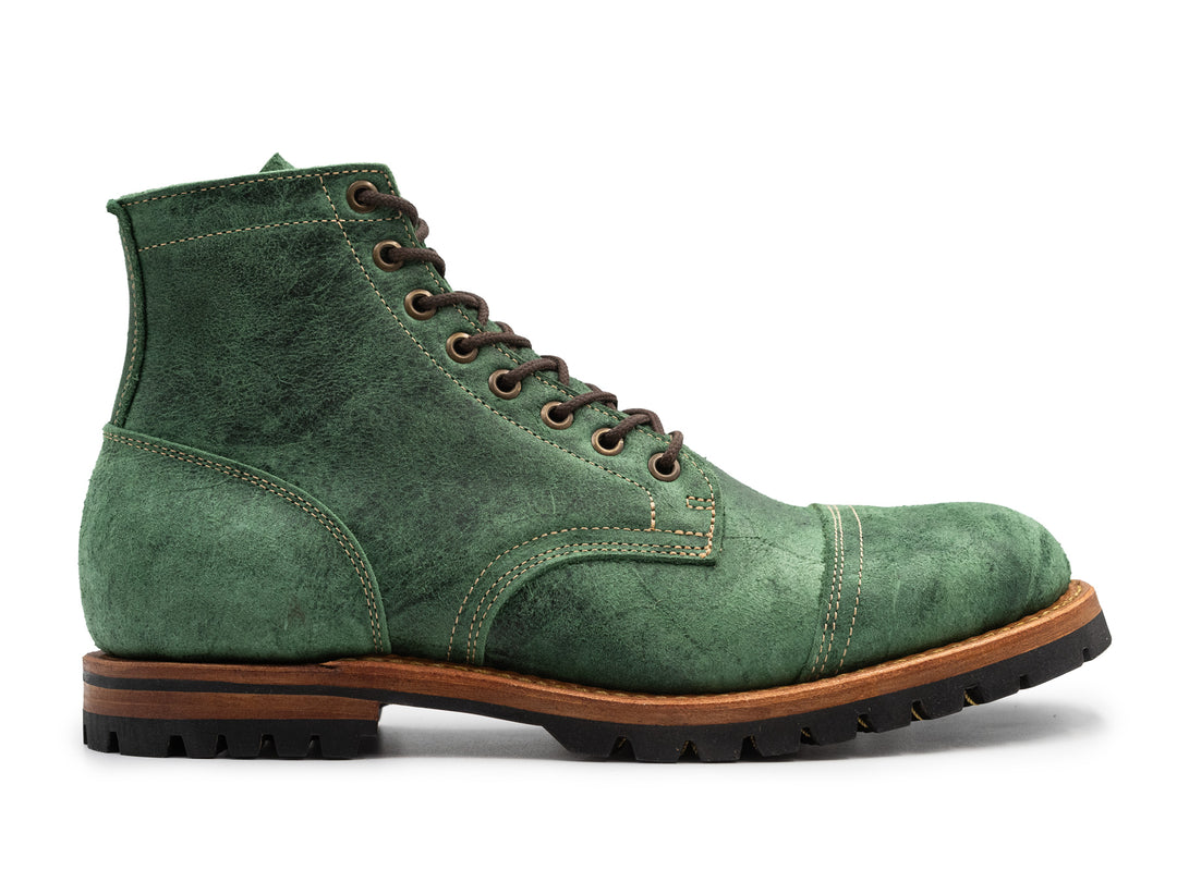 textured spruce green leather boot on white background