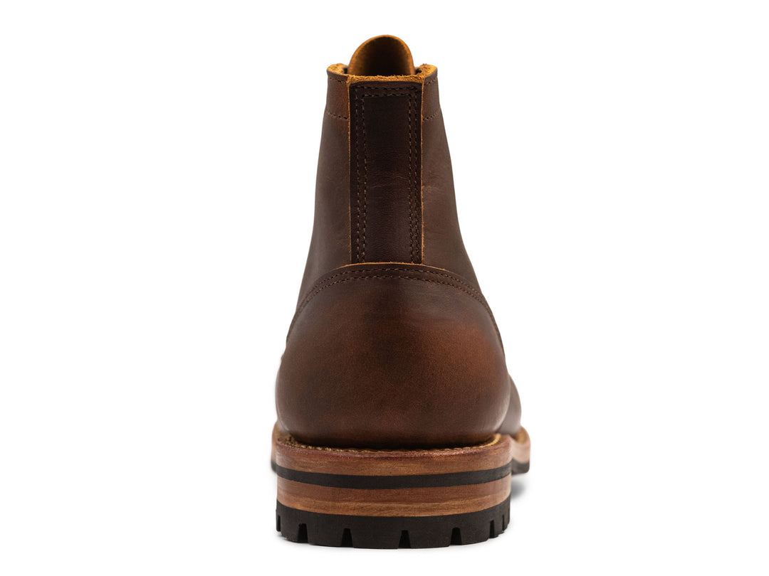 Brown leather boot with a white background view from behind